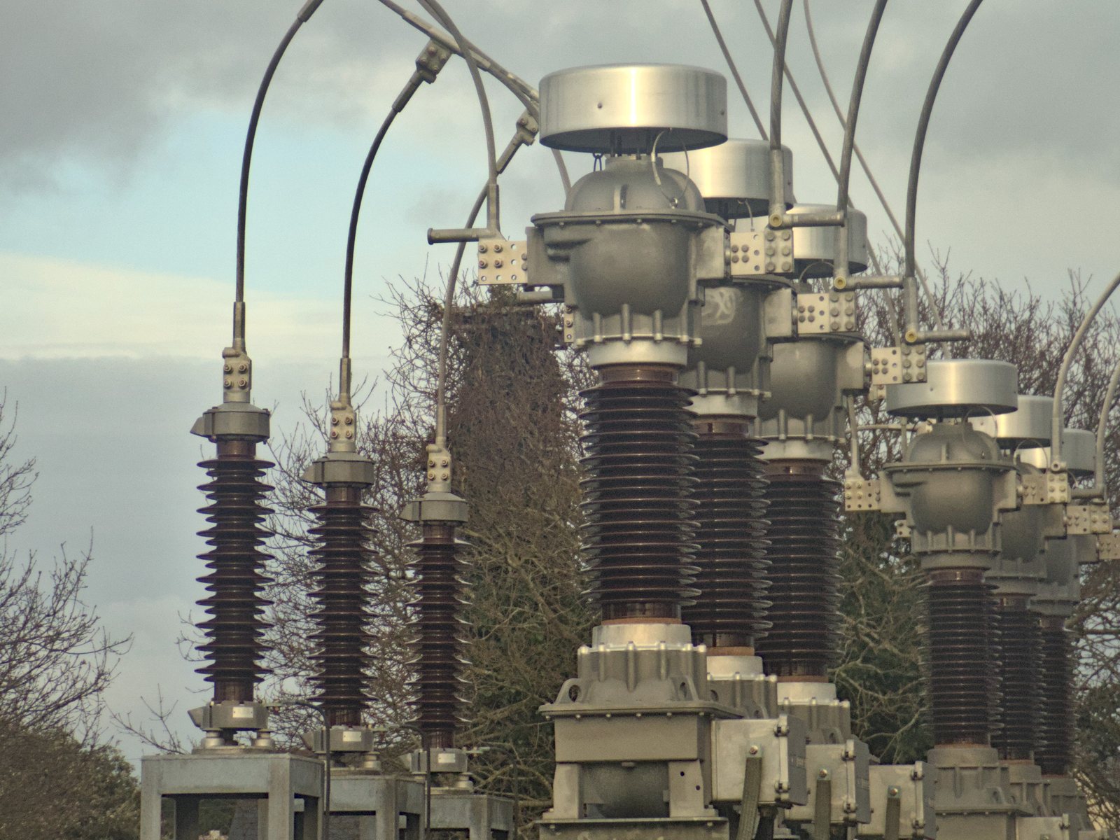 Surge arresters and current transformer at a high-voltage substation.